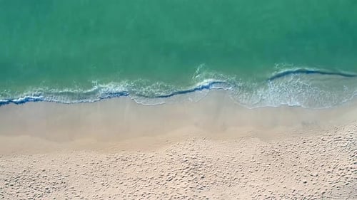Small Waves Lapping Beach Sand Aerial