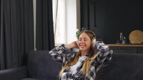 Woman Enjoying Music with Headphones Relaxing at Home