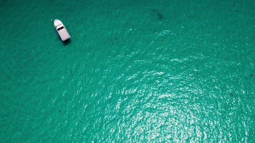 Exploring serene turquoise waters with a lone boat floating above
