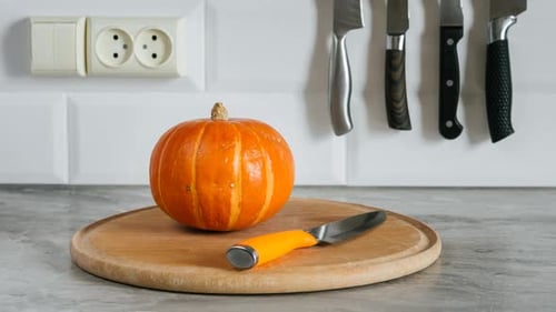 Rotating Pumpkin On A Cutting Board With A Knife With An Orange Handle