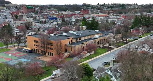 Urban city school in USA. Aerial parallax shot of building in town in United States. American educat