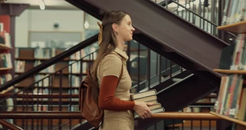 Woman, student and walking in library with books for learning, education or study material