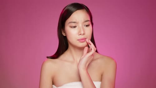Young Asian Woman Itching Skin on Pink Background in Studio