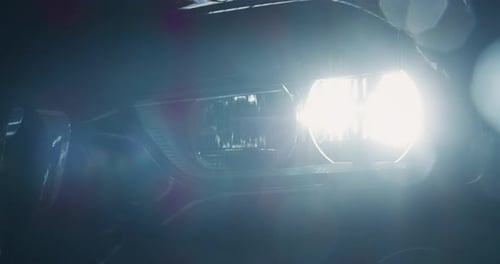 Close up of details of switched on headlights of anonymous prestigious luxury modern car. Shot in