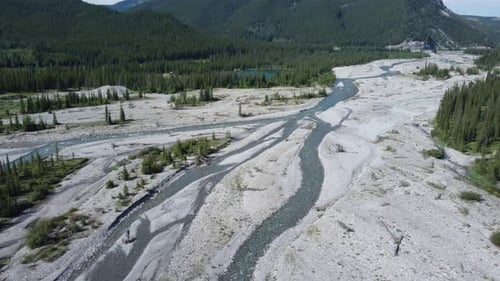 Low drone flying shot over the mountain river revealing waterflow