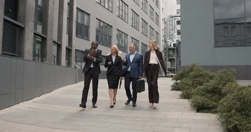 Business People Walking Outdoors Near Office Building