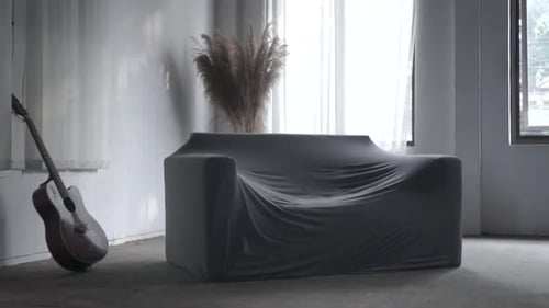 Covered Couch and Guitar in Bright Interior