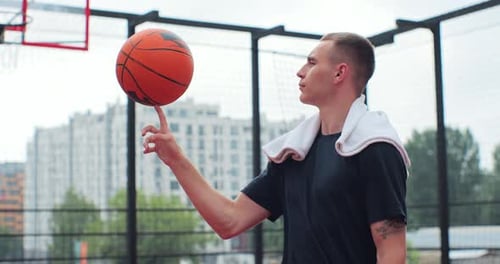 Man Spinning Basketball on Finger Outdoors