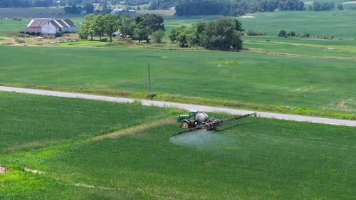 Tractor Spraying Pesticide Fertilizer on Farm Field Agricultural Machinery at Work