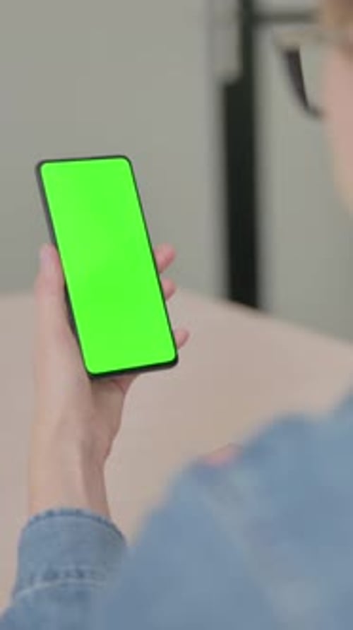 Young Woman using Smartphone with Green Screen, Vertical Video