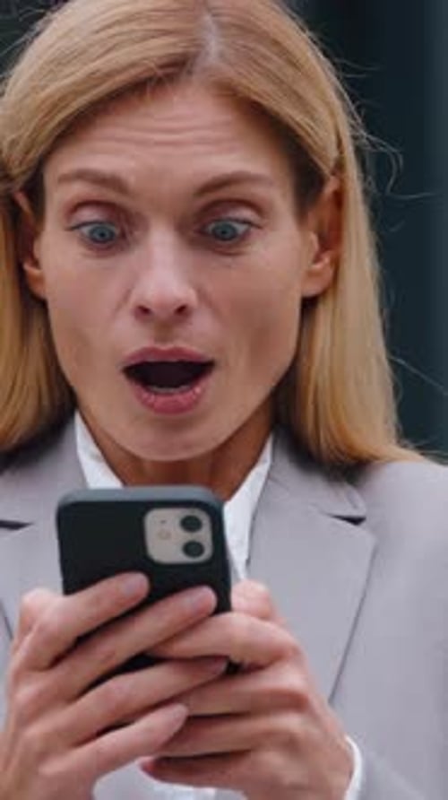 Enthusiastic Happy Caucasian Middleaged Business Woman with Phone in City Saying Wow Receiving