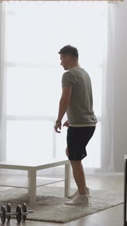 Man Doing Step Up Exercise on Table in Home