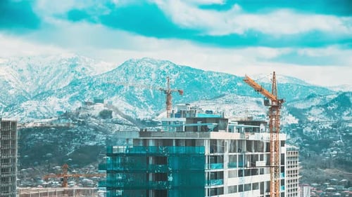 Construction Crane After Working Day Against Mountains Landscape Construction And Development Of