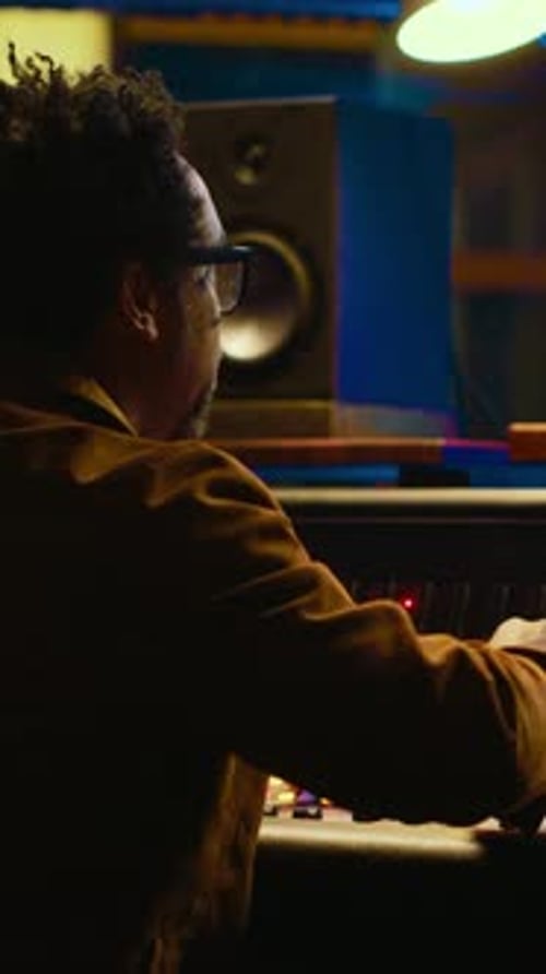 Vertical Video African American Sound Expert Operates on Audio Console with Moving Faders