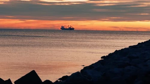 Navires de charge à la voile au coucher du soleil