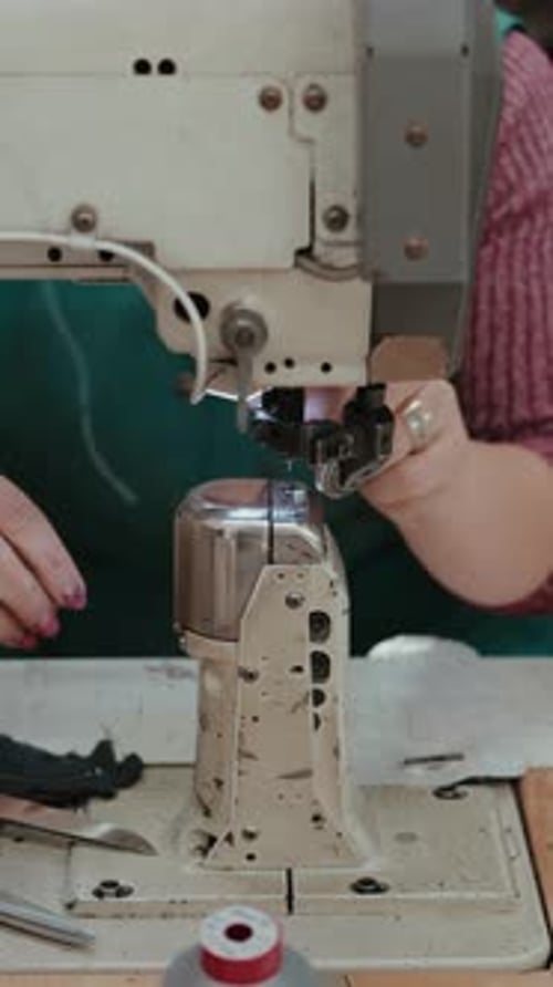 Woman Operating Vintage Sewing Machine in Tailoring Shop