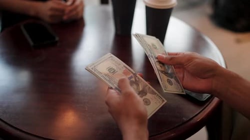 Male hands counting money to pay for products to a vendor in a cafe