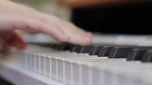 Nahaufnahme männlicher Hände eines Pianisten, der sanft Musik über verschiedene Tasten spielt