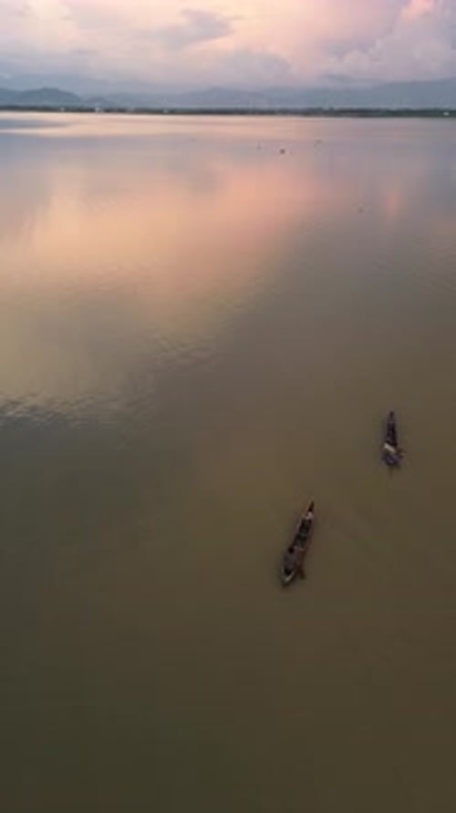 Drone vertical filmé par un pêcheur sur son bateau dans le lac