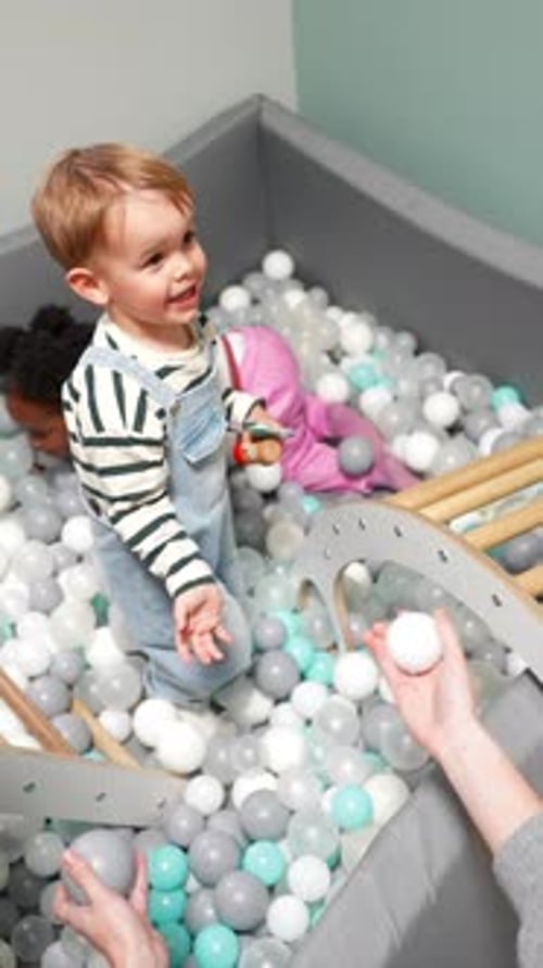 Adorables tout-petits jouant joyeusement dans une piscine à balles à la garderie