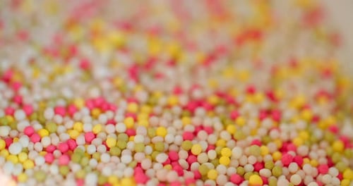 Close-up view of bowl with colorful sugar sprinkles dots for decoration for cake and pastry.