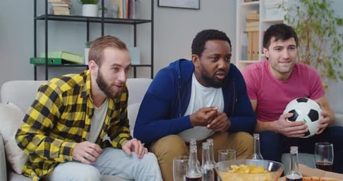 Enthusiastic Friends Watch Exciting Game on TV