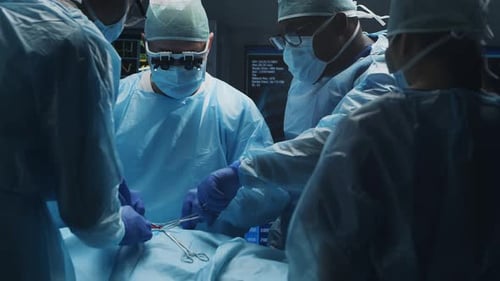 Multiracial Team of Professional Medical Surgeons Performs the Surgical Operation in a Modern