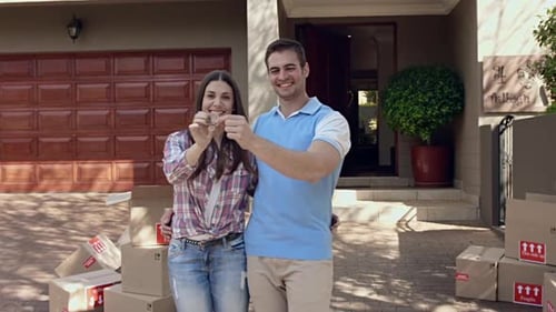 Couple Holding Keys in Front of New House