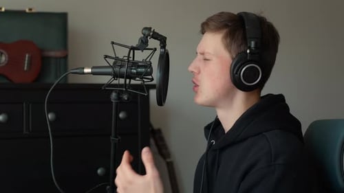 Focused Man Creating Music in a Home Studio with Professional Equipment