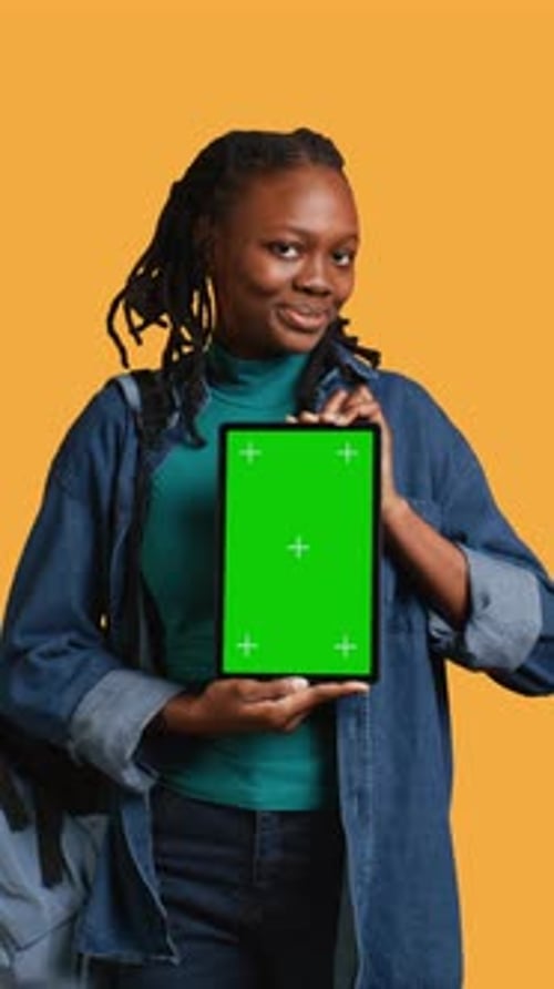 Vertical Video Smiling Woman Presenting Tablet with Green Screen Display Studio Background