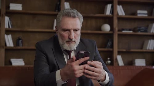 Senior Businessman Using Smartphone in Office