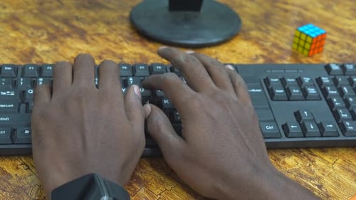 Hands Typing on Computer Keyboard at Desk