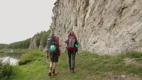 Couple of Mountain Climbers Walking to Rock and Preparing Equipment