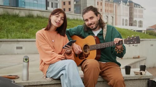 Portrait of Young Couple with Guitar Hanging Out on City Street