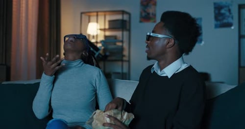 Couple Laughing, Watching Movie Together at Home