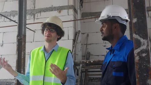 Construction Supervisors Discuss Plans at Building Site