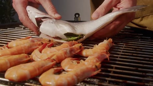 Chef Cooking Shrimps with Oil and Spices on Grill Closeup Prawns on Fire Throwing Them on Pan
