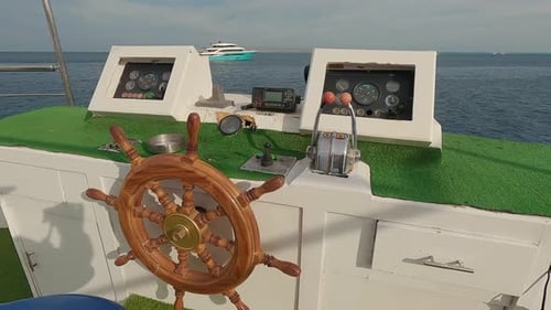 Steering Wheel and Navigation Compass on a Yacht Background of Red Sea. The Concept of Vacation or T