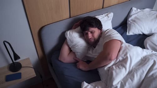 Man Sleeping and Waking Up in Bed