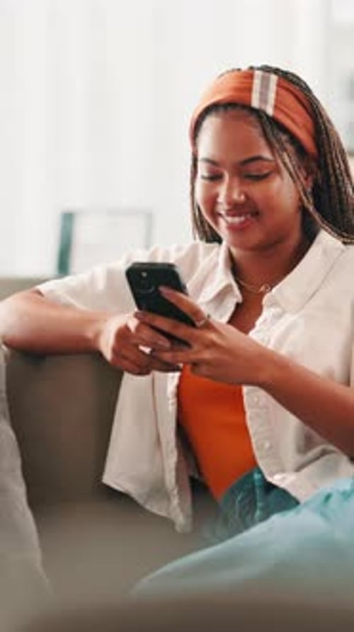 Smiling Young Adult Using Smartphone at Home