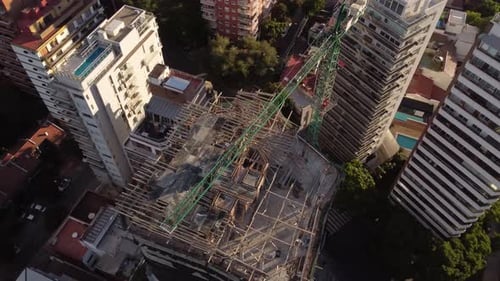 Vista aérea de arriba hacia abajo del sitio de construcción en una torre de rascacielos con grúa en Buenos Aires