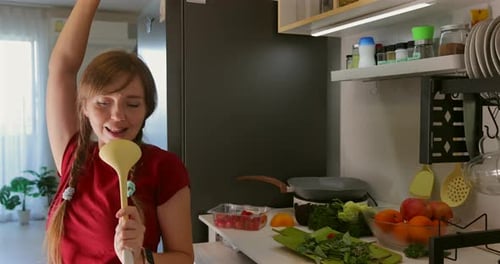 Woman Singing and Dancing in Kitchen with Ladle