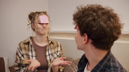 Un groupe d'amis joue à un jeu de devinettes dans un salon lors d'une soirée avec des notes autocollantes