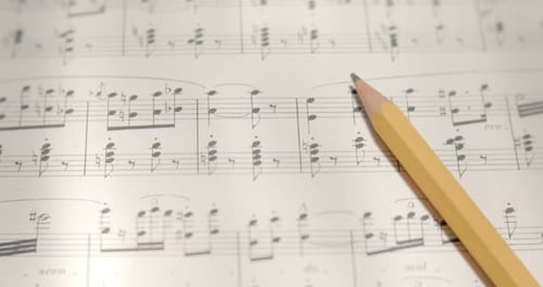 View over musical notes and pencil