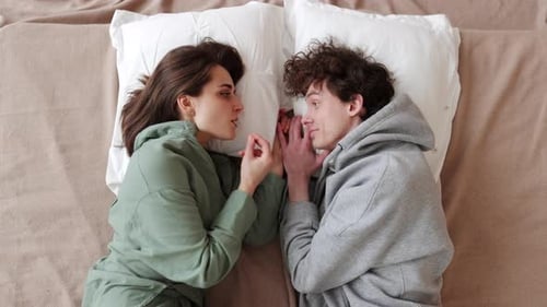 Fotografieren eines verliebten Paares in intimen Momenten auf einem gemütlichen Bett für Stockbilder