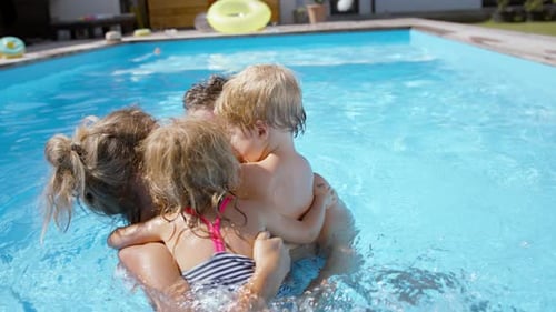 Family Spinning And Having Fun Together In The Pool.