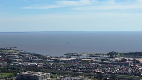 Far shot of an airplane landing on Aeroparque - Buenos Aires with the river in the background, sunny