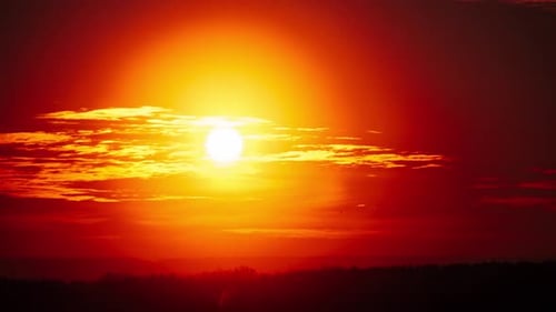 Timelapse of Dramatic Sunset Through Clouds in the Orange Sky Over the Horizon