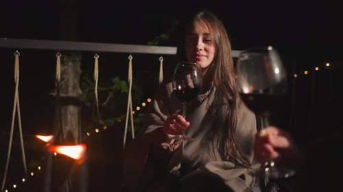 Wife Cheers Wineglass with Husband on Terrace