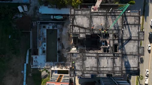 Aerial Video of Workers on Tower Framework Beside Crane